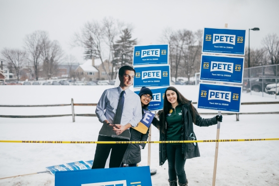 Students hold posters and a human size cut out for Pete Buttigieg