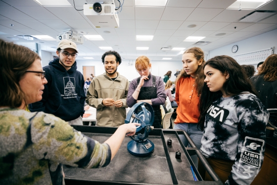 Professor of Physics and Astronomy Robyn Millan discusses a gyroscope with students in her &quot;Physics 13&quot; class