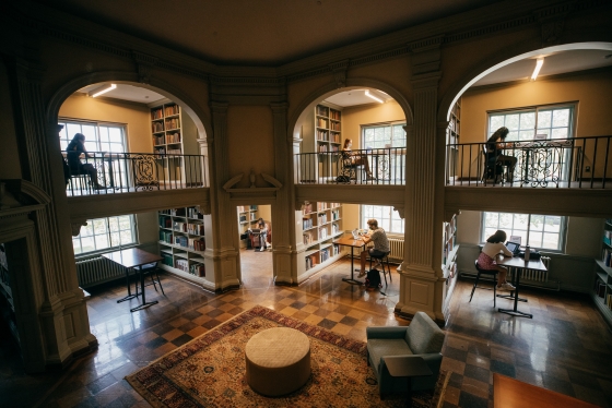 Students studying, separated in different nooks, in the library.