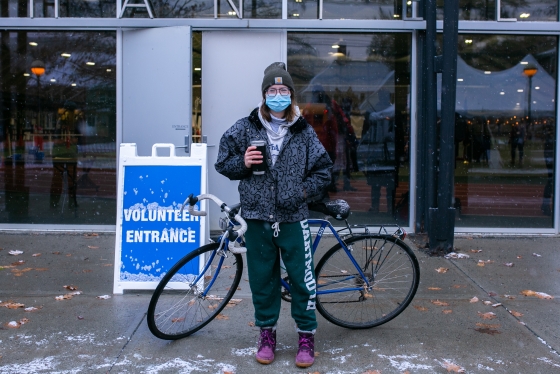 Voter on a bicycle waiting outside in a snow storm to vote