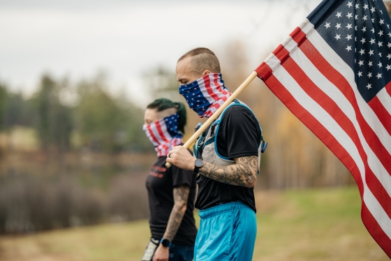 Jason Mosel carries the American flag around Occom Pond with his wife.