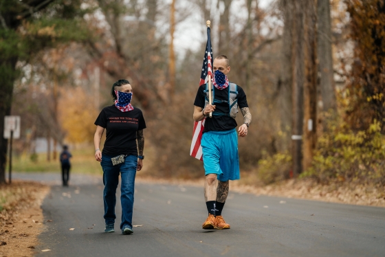 Jason Mosel and his wife carry the American flag around Occom Pond