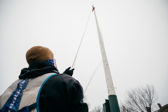 Jason Mosel raises the American flag to the top of the pole.