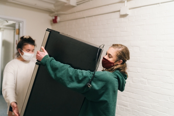 Catherine Trusky '24 and Alissa Amorim '24 move a refrigerator into their dorm room.