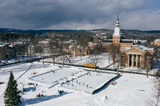 Aerial view of skating rinks on the Green, Baker Library, and mountains