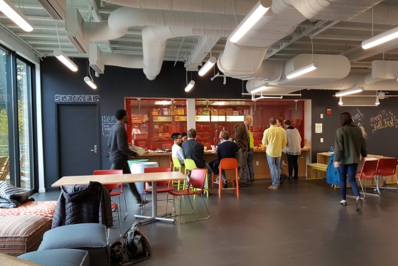 Students, house professor, and staff gather in a social space
