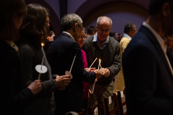 Phil Hanlon '77 lights a candle at the MLK multifaith ceremony