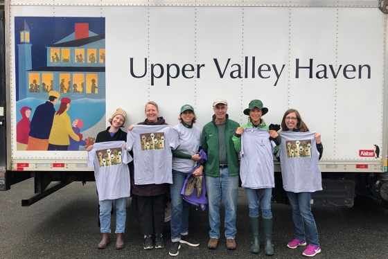 Members of the president's office stand in front of a truck with the Upper Valley Haven logo on it