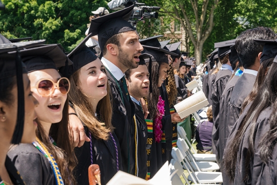 Students sing the alma mater at commencement.