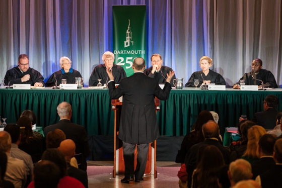 Gregory Garre ’87 standing at a podium in front of a panel of distinguished alumni jurists