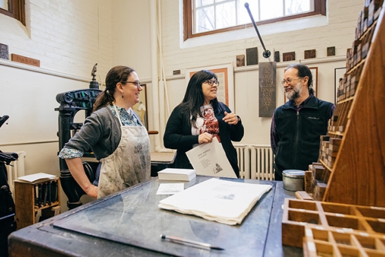 Sarah Smith, director of the Book Arts Workshop, and workshop participants Candessa Tehee and Ed Rayher demonstrate printing with Cherokee type in the Book Arts Workshop.