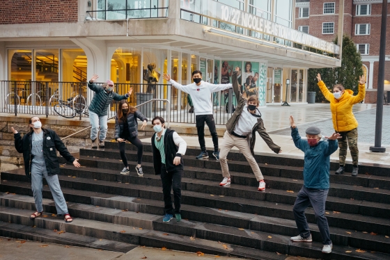 Hanover-based cast and crew of Faith, Hope, and Charity posing dramatically on Hopkins Center steps, masks on.