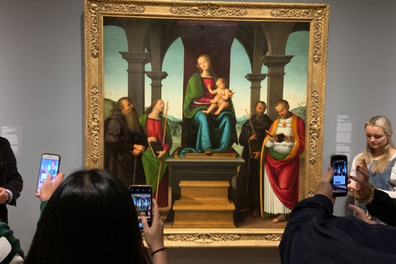 With Associate Professor of Art History Nicola Camerlenghi, left, students test out the new Augmented Dartmouth app on Perugino's Virgin and Child with Saints in the Hood Museum of Art.