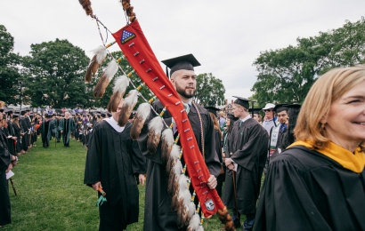 Person carrying Native veterans flag at commencement