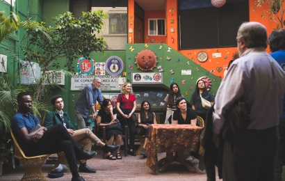 Students and others gathered in a green and orange room