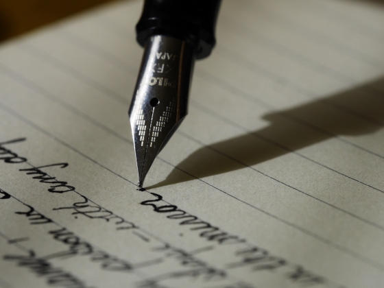 lined note paper and a fountain pen, words written in cursive