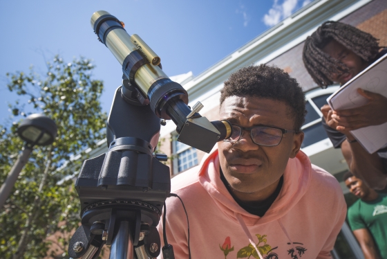 Student looking through a telescope