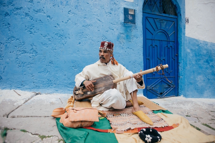 Man playing instrument in blue city