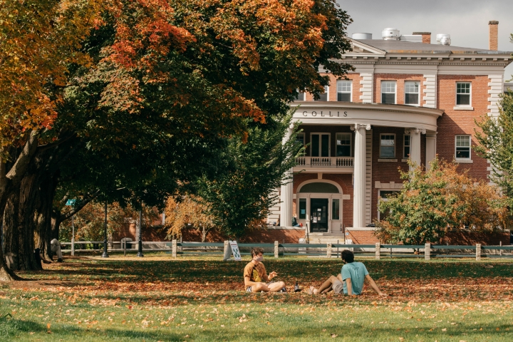 Two students sitting on the Green outside of Collis