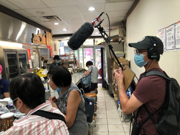 Daniel Lam '22 uses a boom mic for interviewing at a café