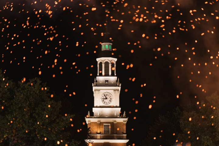 Sparks from the 2021 homecoming bonfire in front of Baker Tower