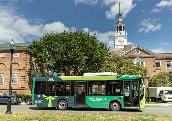 Green shuttle with D-pine logo in front of Baker Library