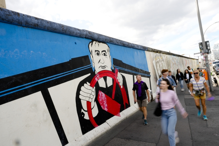 Tourists pass a mural of former Soviet President Mikhail Gorbachev