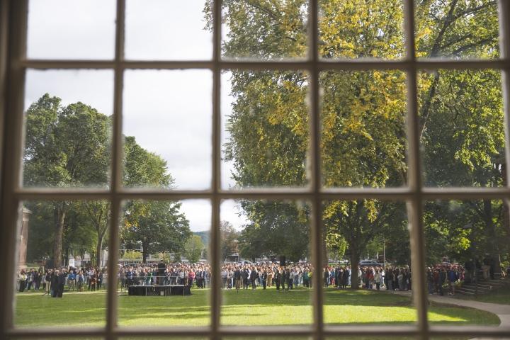 Looking out through a paned window onto a crowd gathered on Baker-Berry lawn