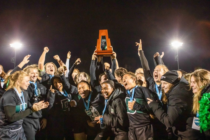 Dartmouth Women's rugby hoisting trophy