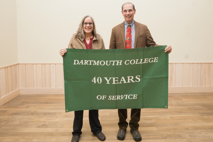 Two people hold a 40 years of service banner