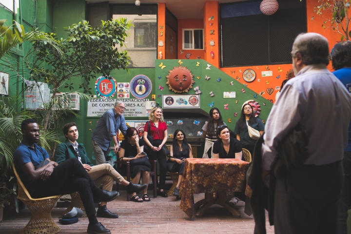 Students and others gathered in a green and orange room 