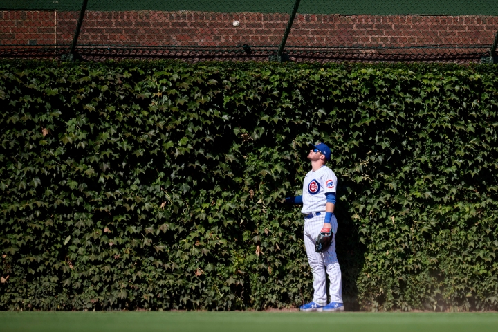Outfielder staring at a home run ball outside the fence in Wrigley Field