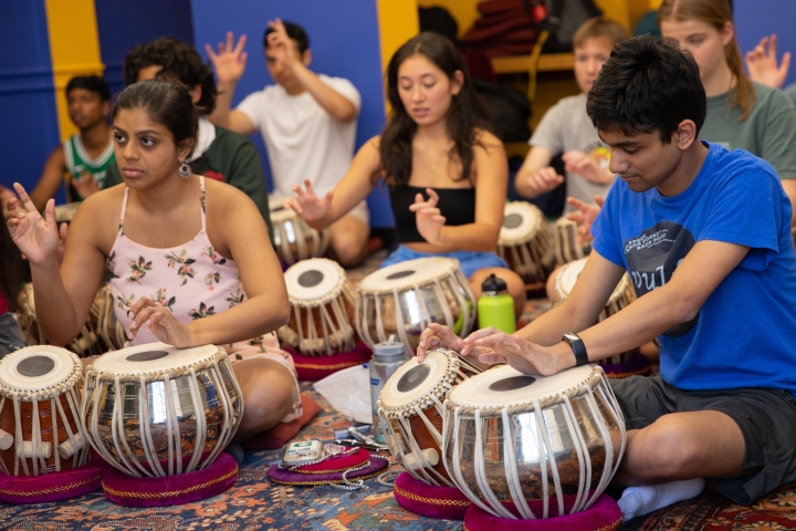 Students play drums from India