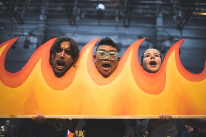 Three people posing by flame set piece