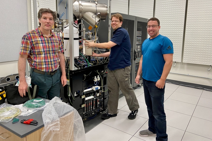 Maxime Guinel de France, Patrick Dean, and Luke Metraw install a new electron microscope