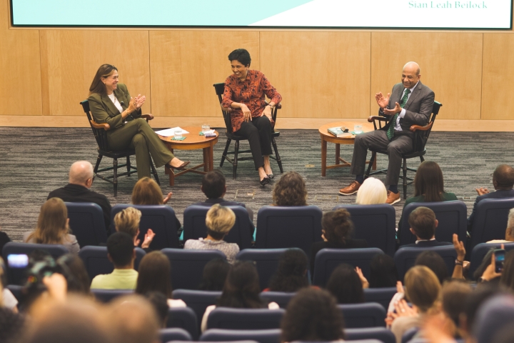 Three people on stage for a talk