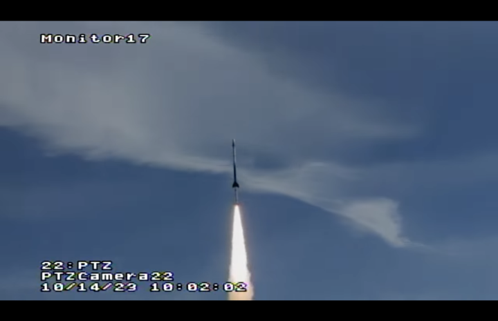 Rocket flying upward through a blue sky.