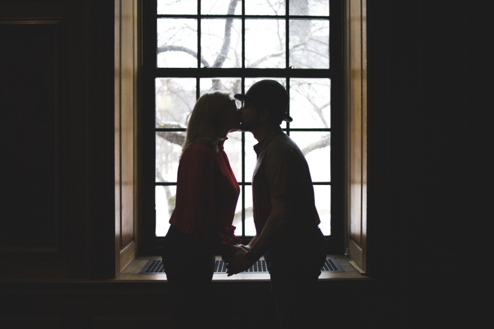 Tammara Wood and Scott Gerlach kiss in front of a window