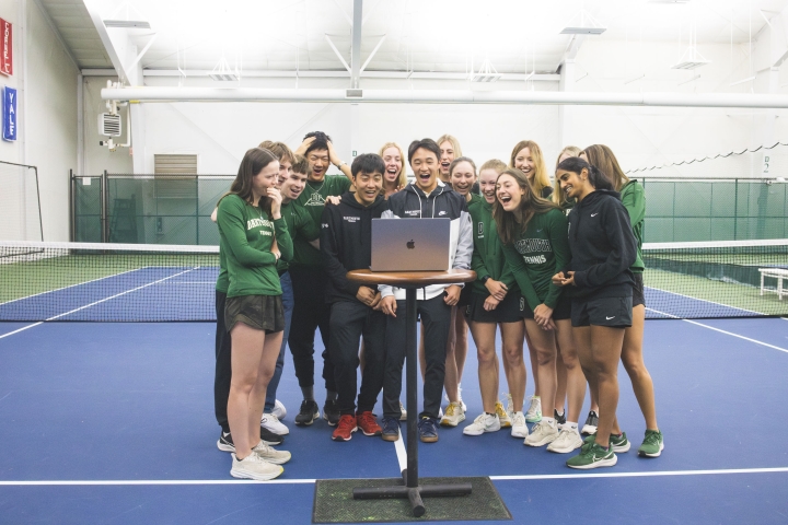 Tennis team around a laptop