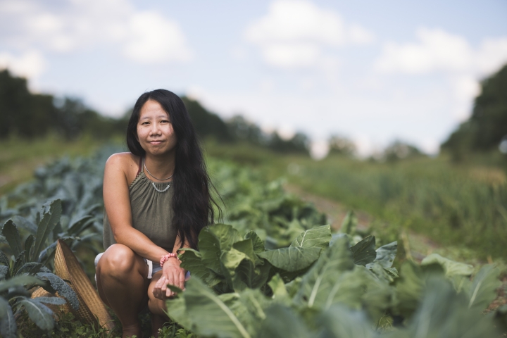 Theresa Ong crouching amidst crops