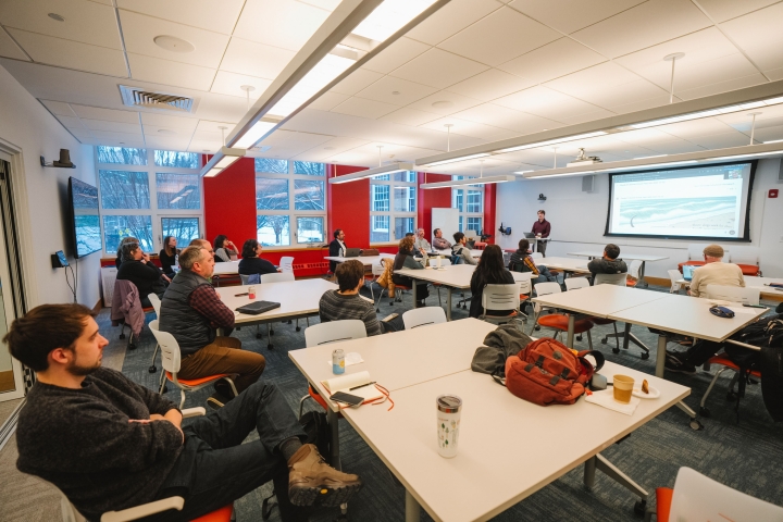 Faculty members at tables in a classroom