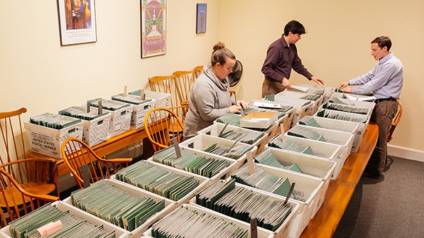 Staff members from the admissions office sort through admitted student packets