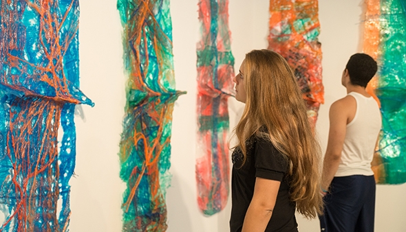 Visitors take a look at artwork by Bogyi Banovich ’11