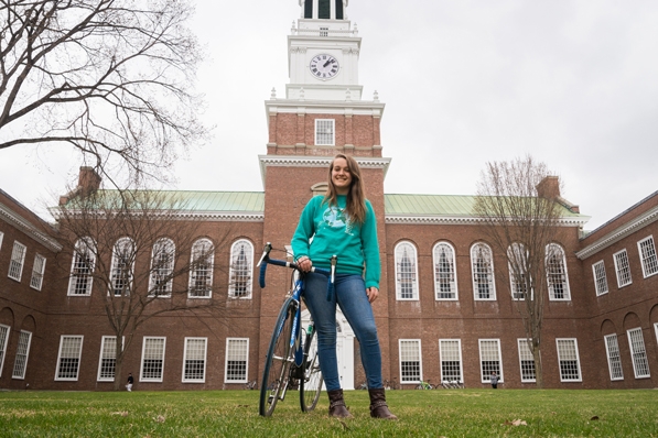 Morgan Curtis with her bicycle in front of Baker Library
