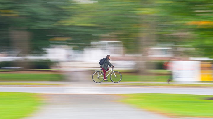 a student riding her bike across campus
