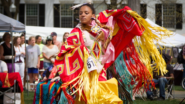 a dancer wearing colorful traditional Native American dress