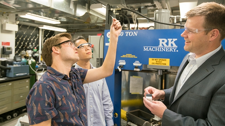 students and their professor examine a sample of a polyethylene-based material 