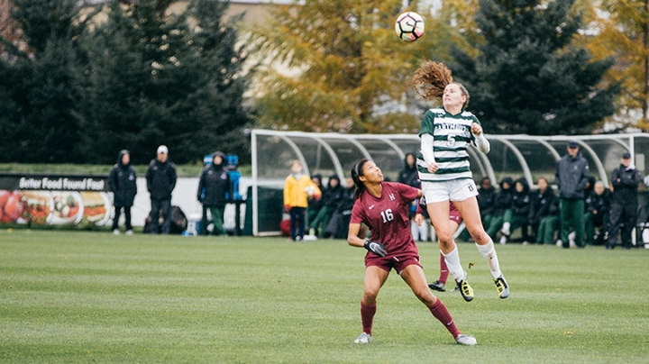 two female student athletes playing soccer