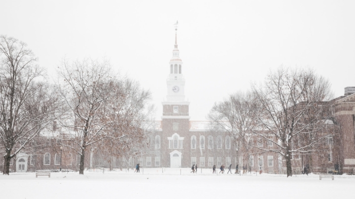 Baker Tower in the snow with students walking by along the sidewalk