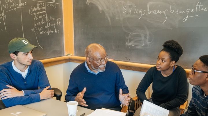 Students talk to Johnnie Carson in a classroom